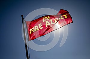 Flag against blue sky that reads `Fire Danger` photo
